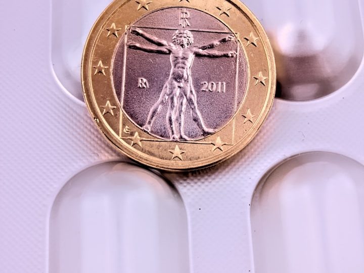 Eine ein Euro Münze mit dem Vitruvianischen Menschen auf einer Tabletten-Blister-Packung.